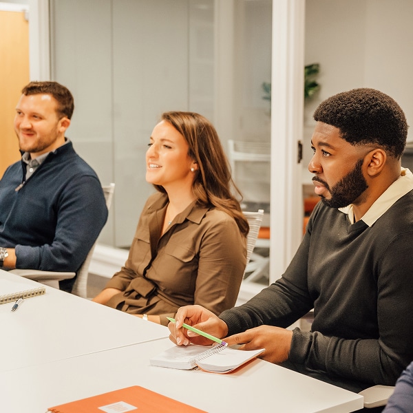 Three colleagues collaborate at a conference table in a modern office